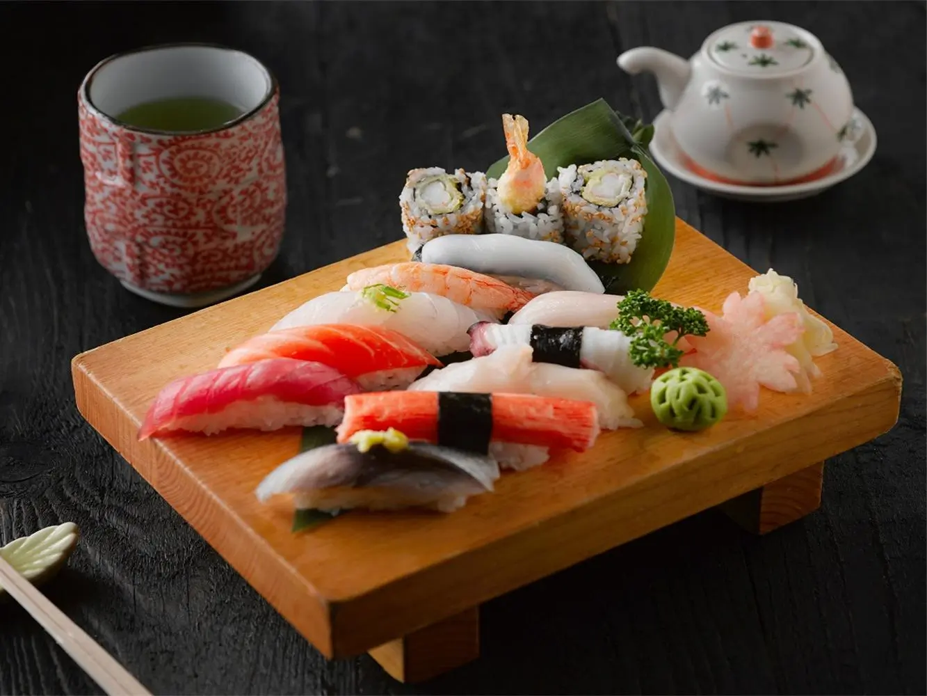 A platter of assorted sushi including nigiri and maki, served with green tea at Hokkaido Sushi & Ramen, a Japanese restaurant in Vancouver